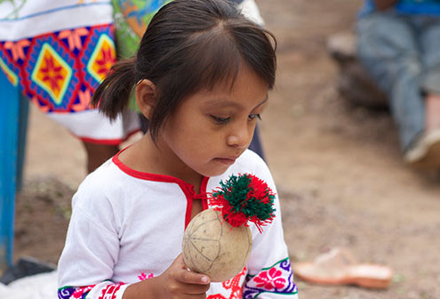 Huichol girl with a ceremonial rattle