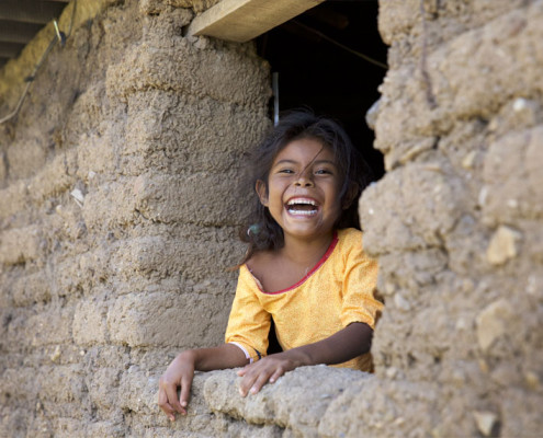 Huichol Girl Laughing in hut window